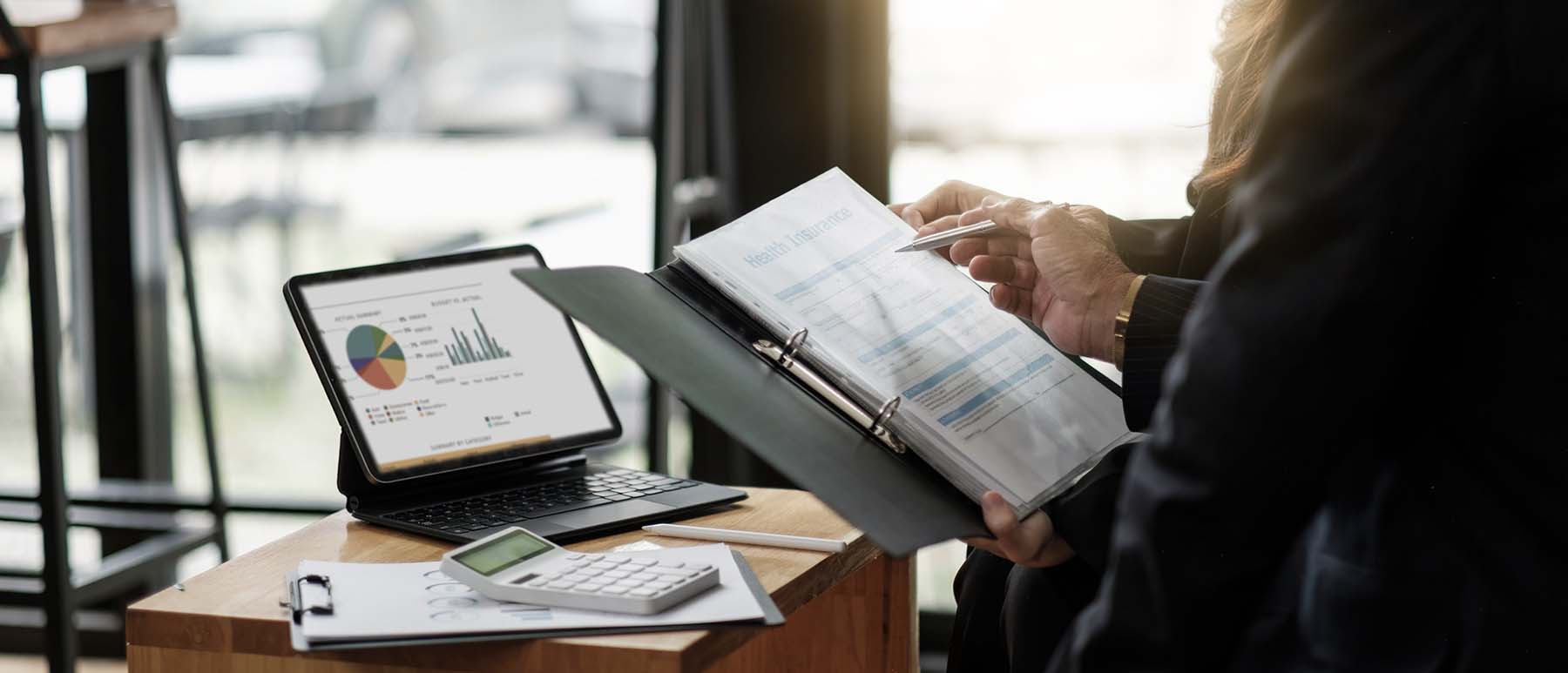 Person at desk in front of notebook and computer