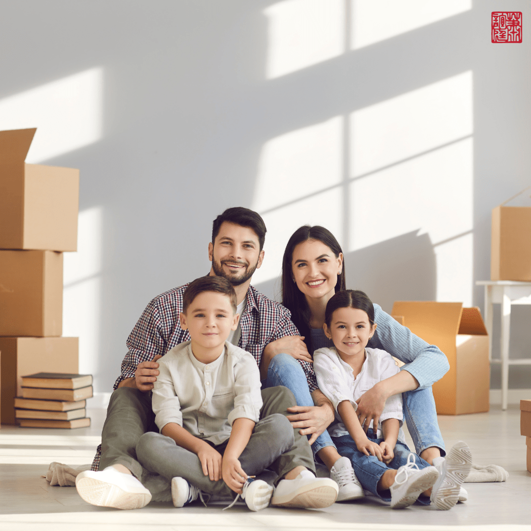 A photo of a family inside a room with move in boxes